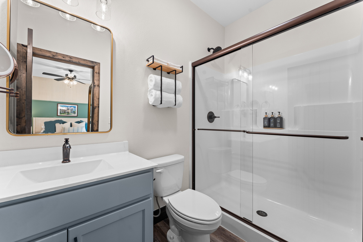 Each of the six bedrooms have their very own private ensuite bathroom. This ensuite bathroom offers a quartz vanity, rattan mirror, and a walk-in glass shower.