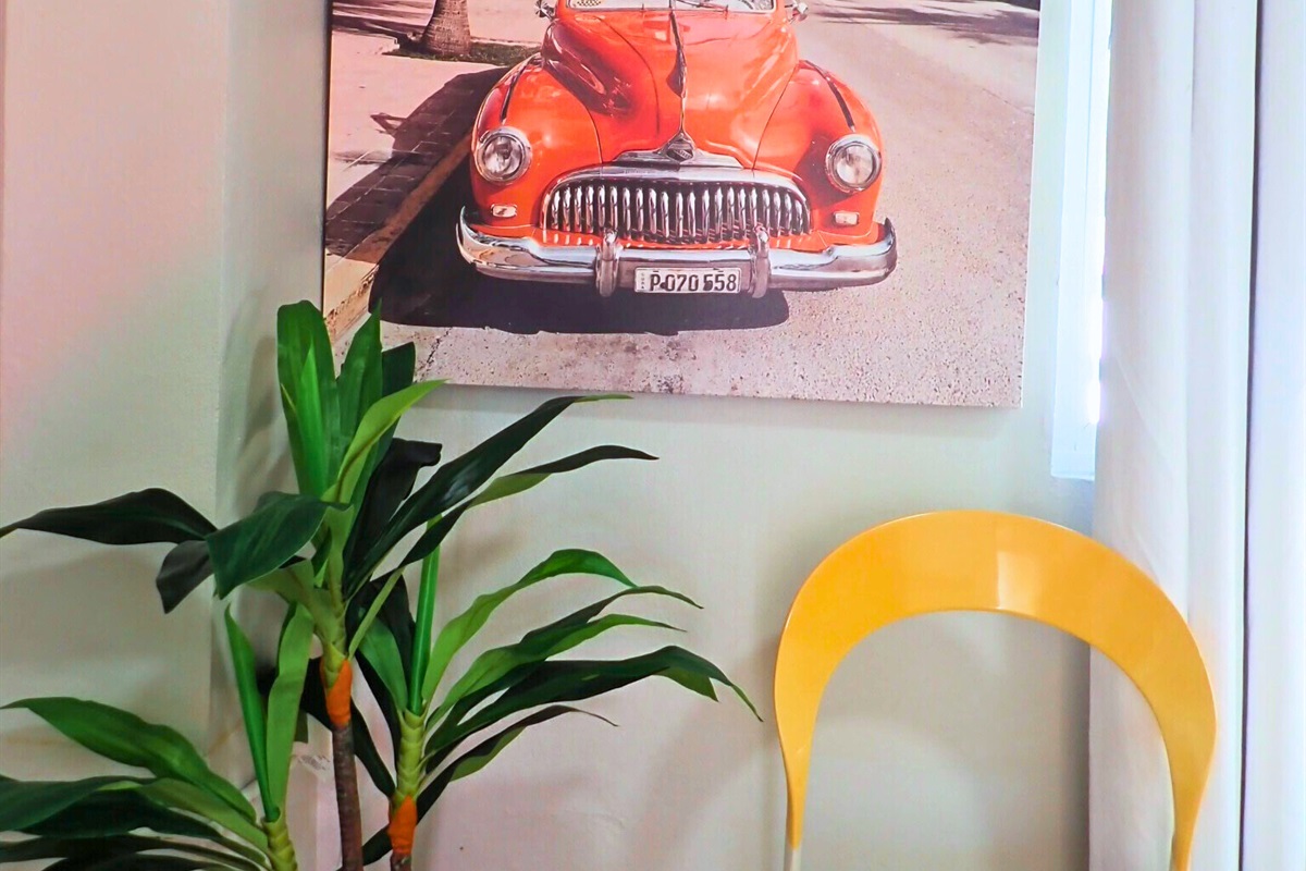 Artistic Nook: Vibrant decor with palm trees and a classic car for a tropical vibe!