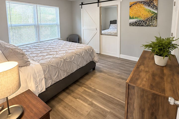 Bedroom Retreat: Tranquil space with natural light, comfortable queen bed with clean beddings and sleek wooden finishes.