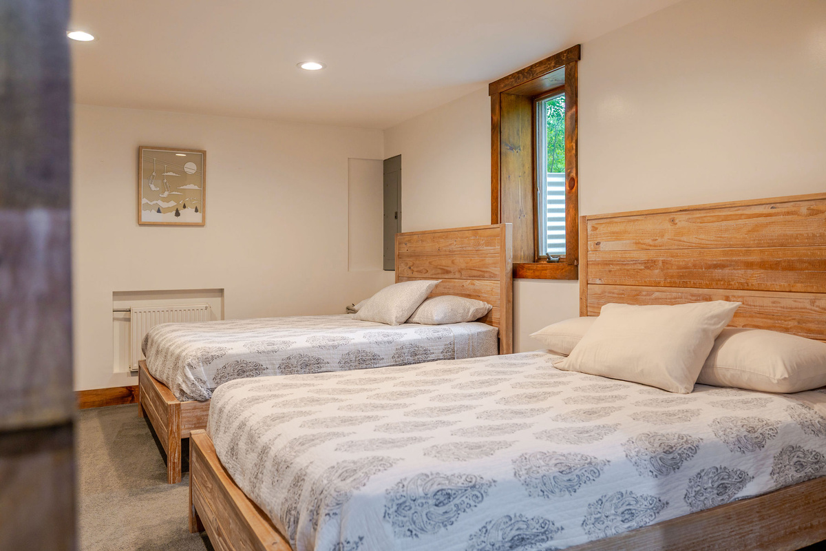 Lower-level bedroom features two queen beds, making it perfect for kids, teens, or multiple couples.