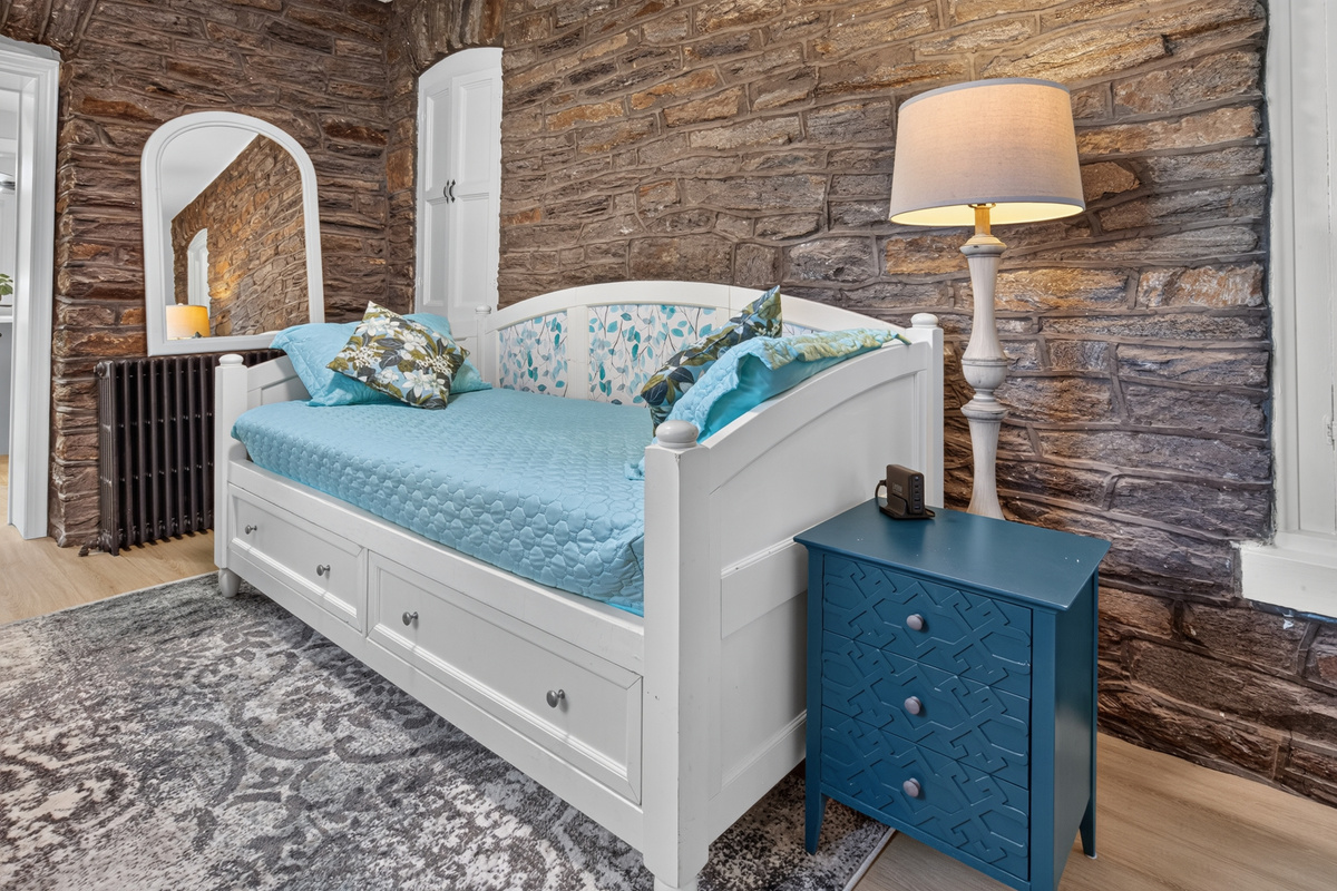 Third private sleeping space featuring a Twin daybed set against an exposed natural stone accent wall.