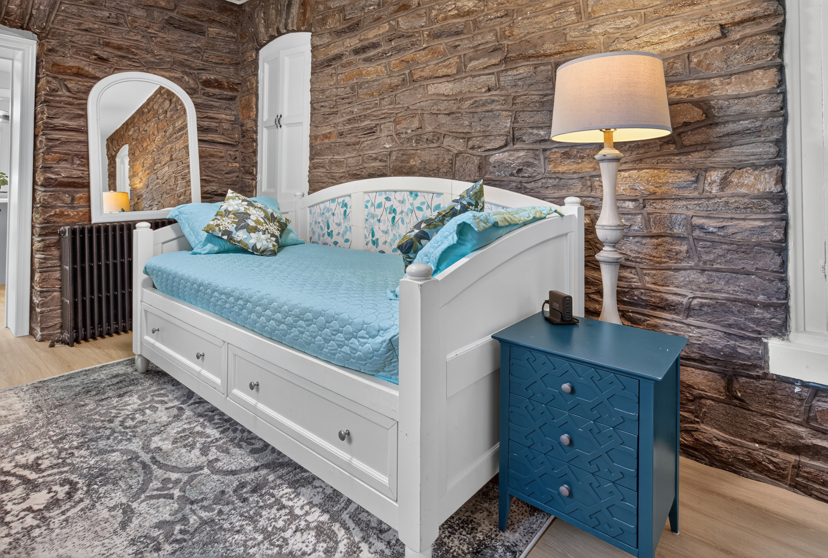 Third private sleeping space featuring a Twin daybed set against an exposed natural stone accent wall.
