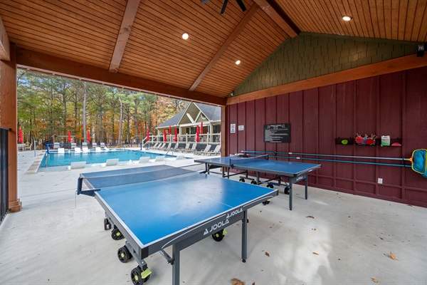 Clubhouse area with covered ping pong tables, lounge seating, and a large outdoor pool—ideal for family fun during your Broken Bow stay. 🏓🏊‍♀️🌲