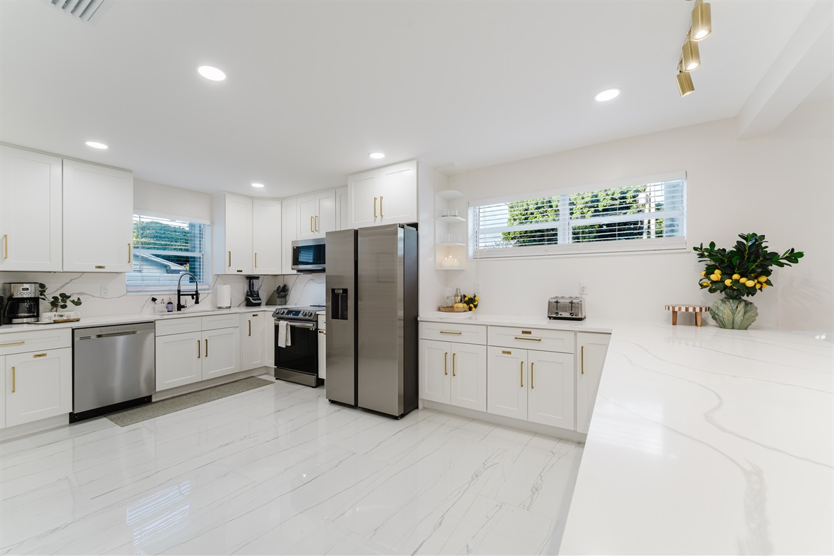 Bright, open-concept kitchen with quartz countertops, stainless steel appliances, and abundant prep space—perfect for family meals and entertaining. Fully stocked with a premium coffee setup, modern finishes, and seamless flow to dining and outdoor areas.