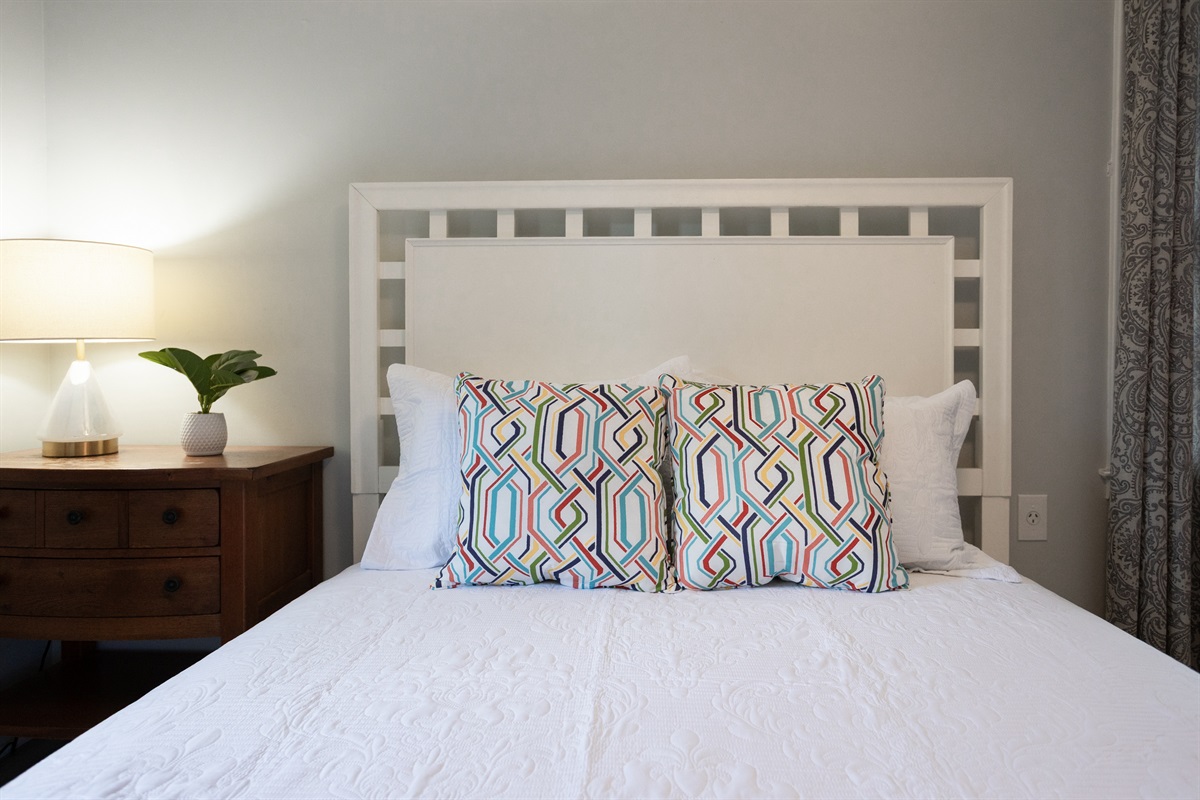 Bright, clean, and cozy—crisp white sheets with a cheerful pop of color.