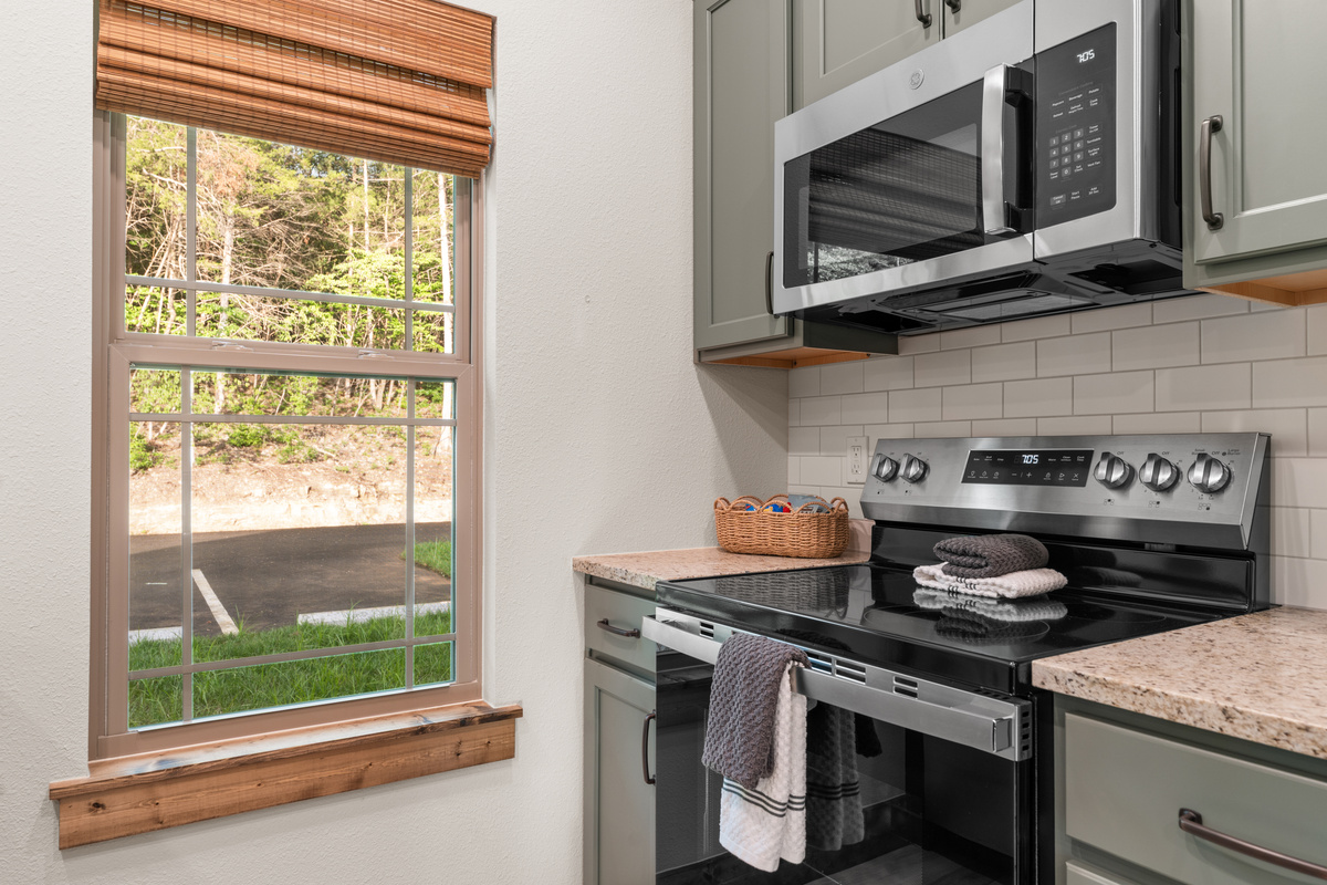 Whip up dinner at the electric range with the woods framed in the window over the counter.