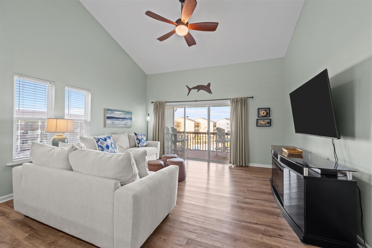 Open living space with vaulted ceilings and direct access to the balcony views