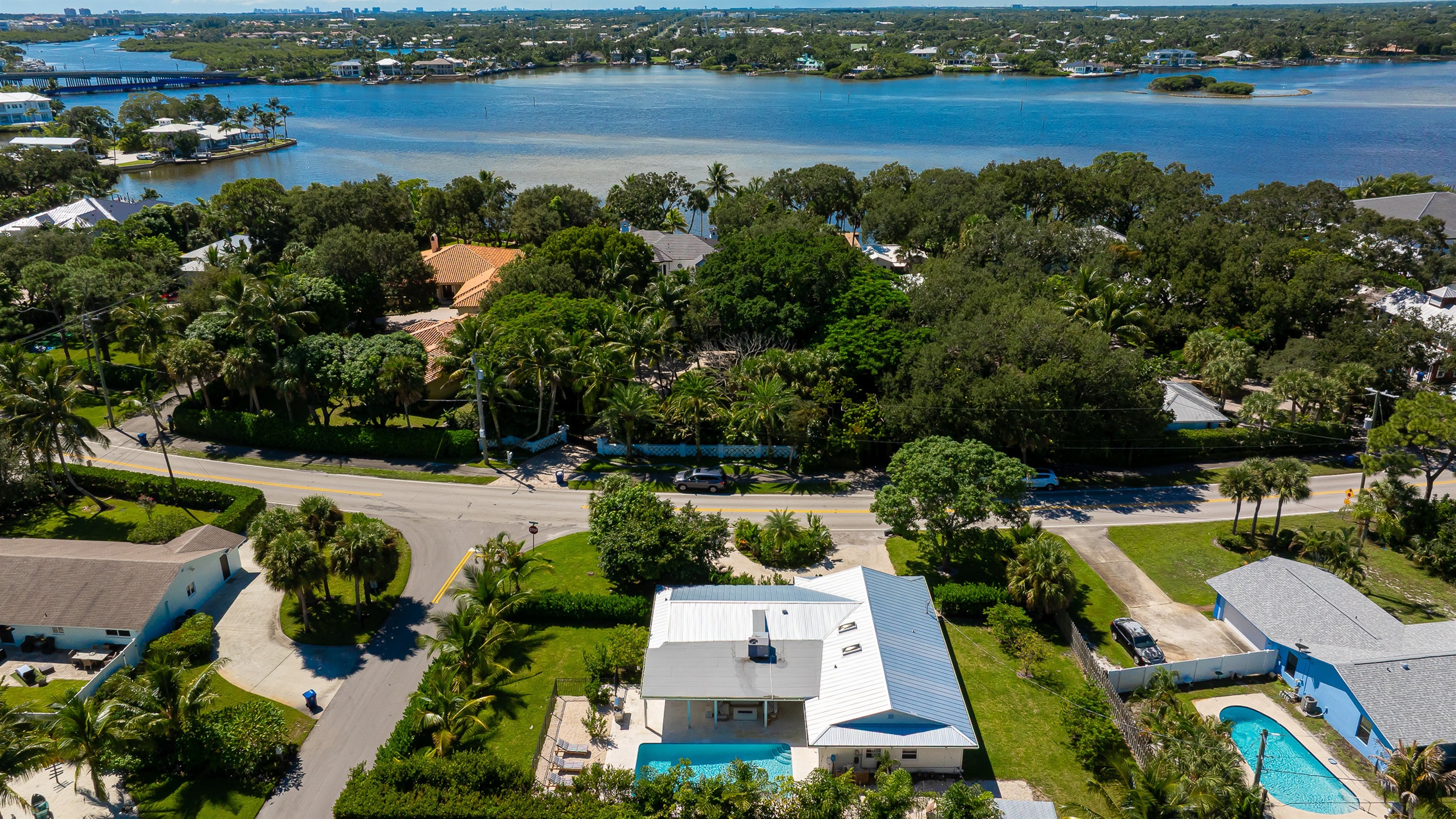 A stunning aerial view captures this luxury coastal retreat with a sparkling pool, manicured lawns, and lush tropical landscaping - offering the perfect blend of privacy, sophistication, and resort-style living just minutes from the beach.