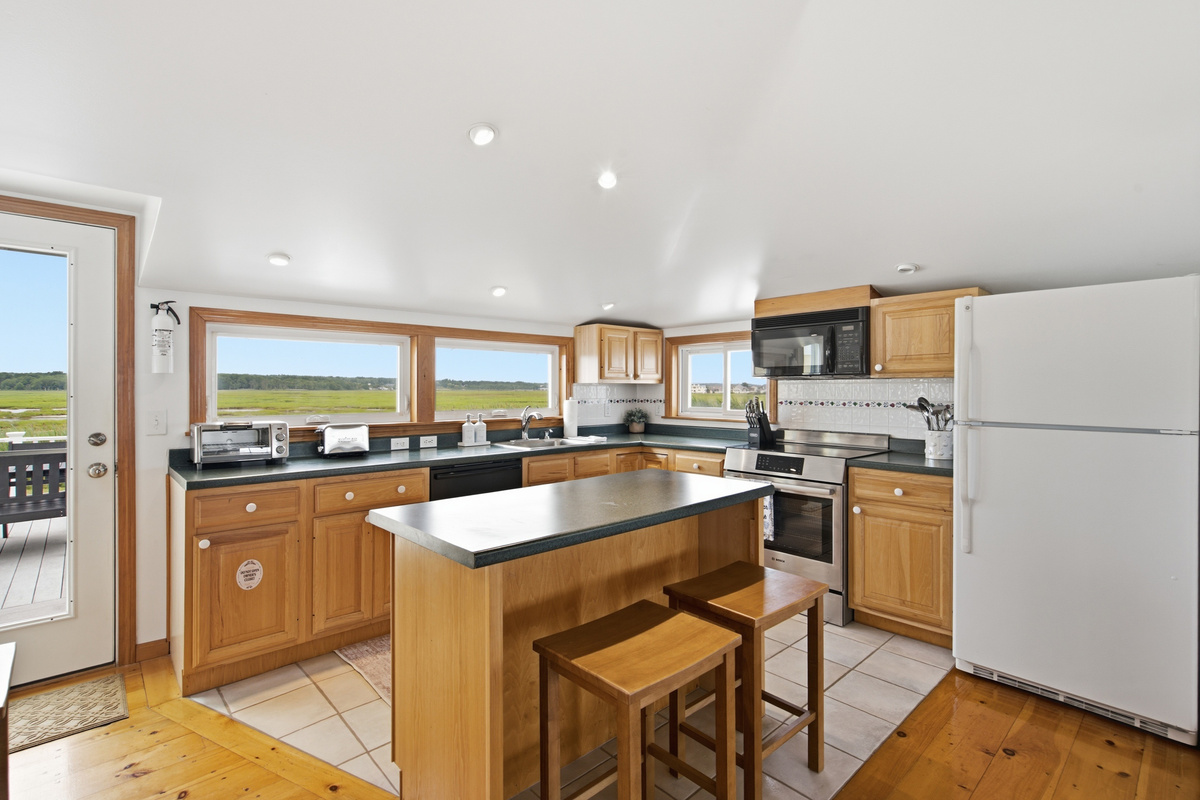 Spacious kitchen featuring stainless steel appliances, ample counter space, and bar seating.