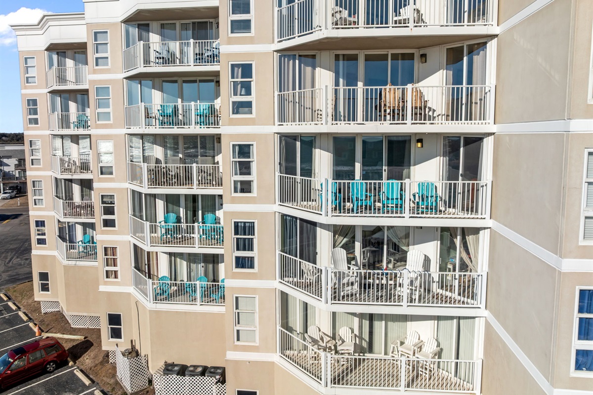 Wide exterior perspective of St. Regis building 1, showcasing ample balconies and a prime coastal location