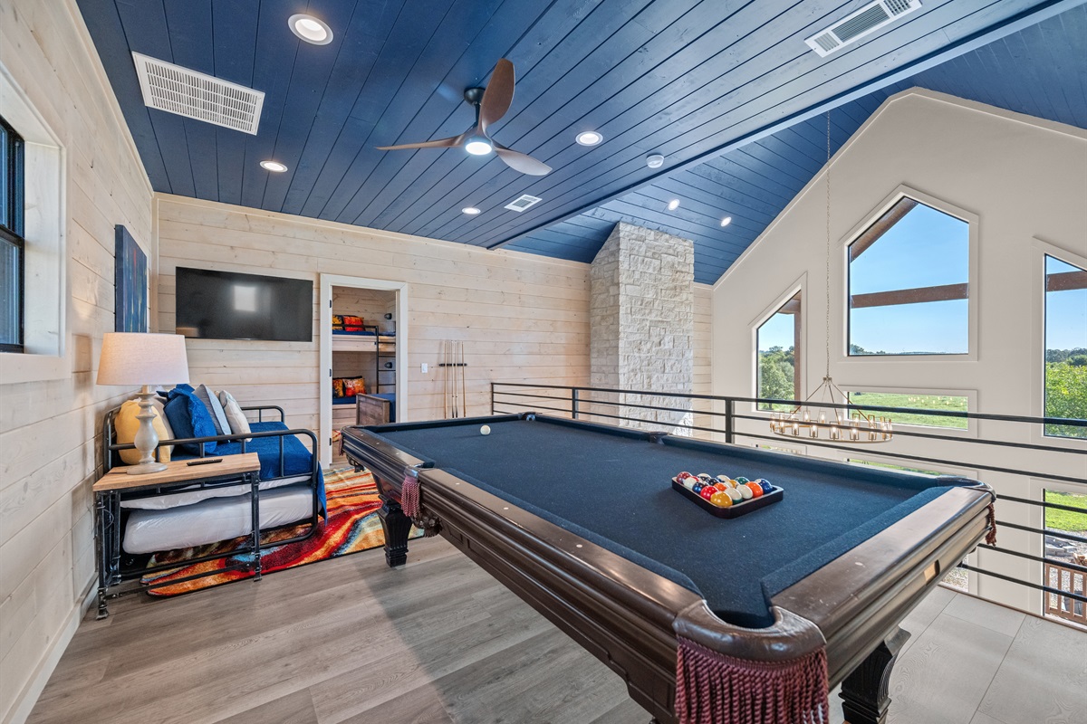 Game room with pool table, cozy seating, and TV. Great for relaxing and hanging out with friends or family.