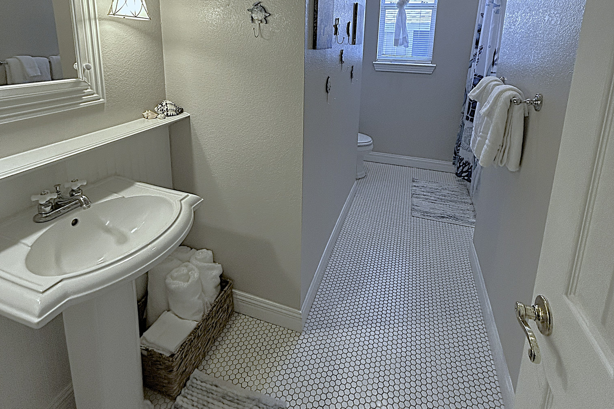 The spacious bathroom offers plenty of room to get ready for the day and ample space to hang and store beach towels after a day in the sun.