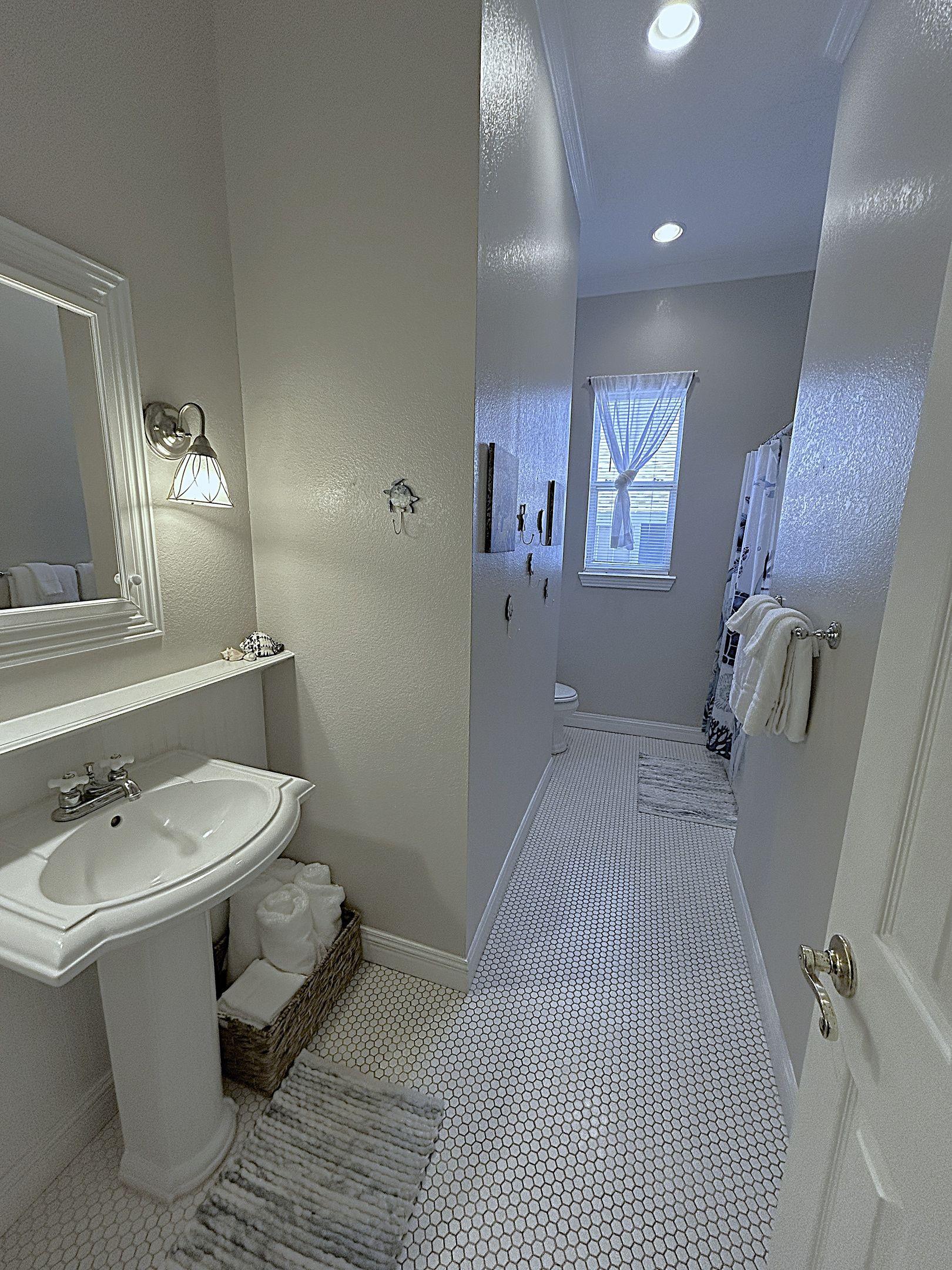 The spacious bathroom offers plenty of room to get ready for the day and ample space to hang and store beach towels after a day in the sun.