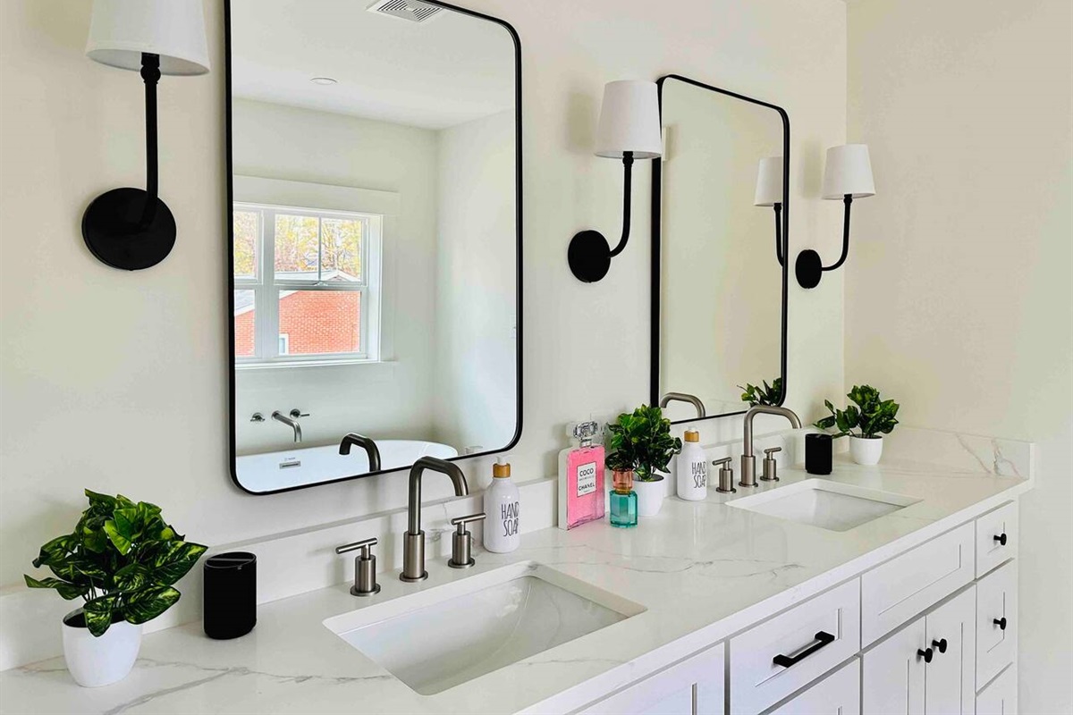 His and her sinks in the ensuite bathroom off the primary suite. A king-sized bed and double vanity makes this the perfect getaway.