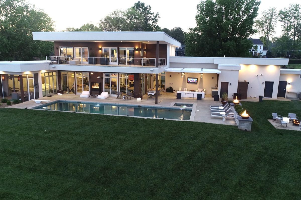 Lavish pool, hot tub, outdoor tv area, double sided fireplace, two firebowls, and fire pit area