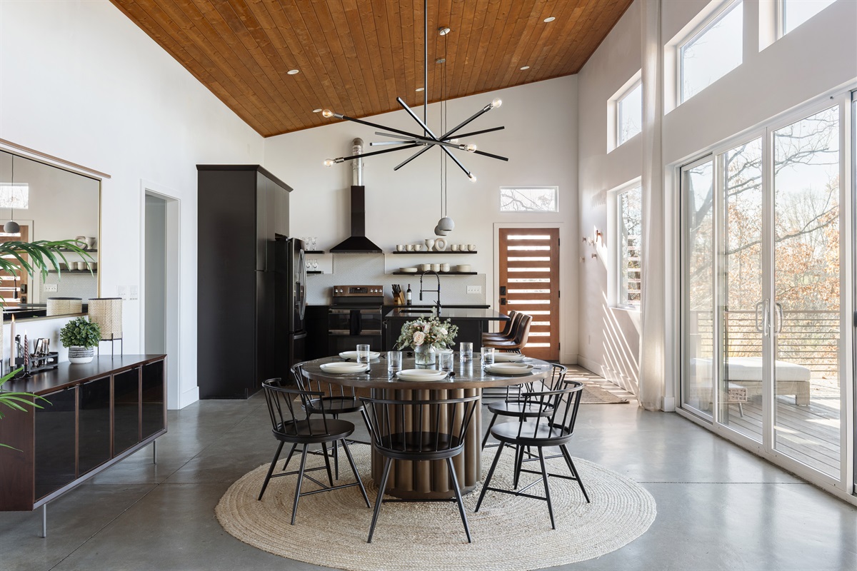 {Kitchen - Glass House} Floor-to-ceiling windows, modern finishes, and a stylish round table ready to serve 10—your group’s favorite gathering spot.