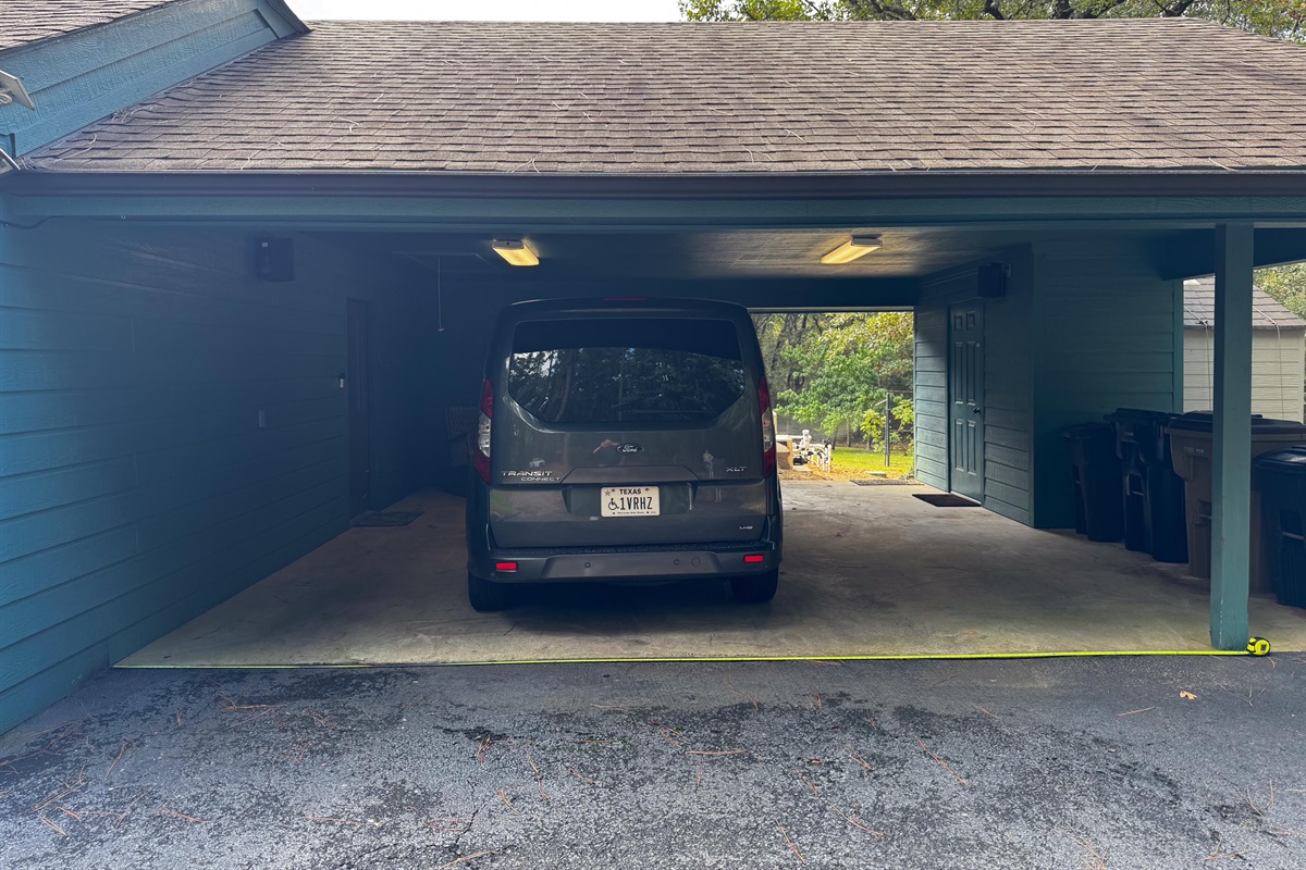 View into the carport where the garbage cans are.