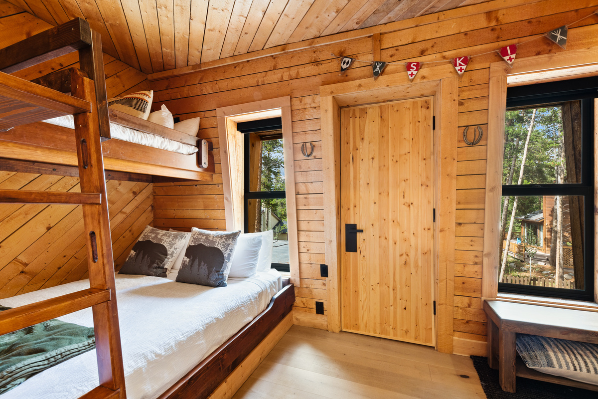 Twin-over-Queen bunk room with twin sleeper. This room can sleep up to four. Door in center is a walk-in closet (does not open to a balcony or outdoor space). 