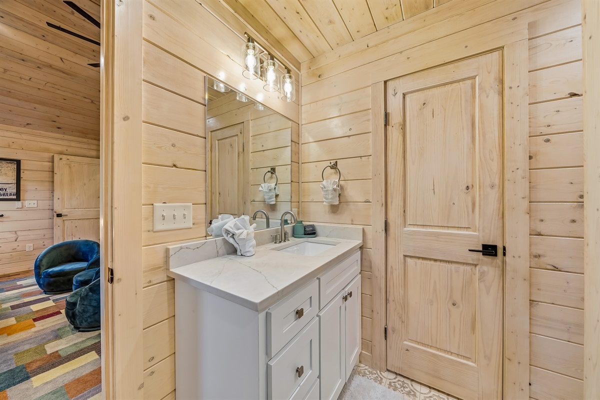 A charming bathroom with a clean modern vanity, soft lighting, and plenty of space to get ready.