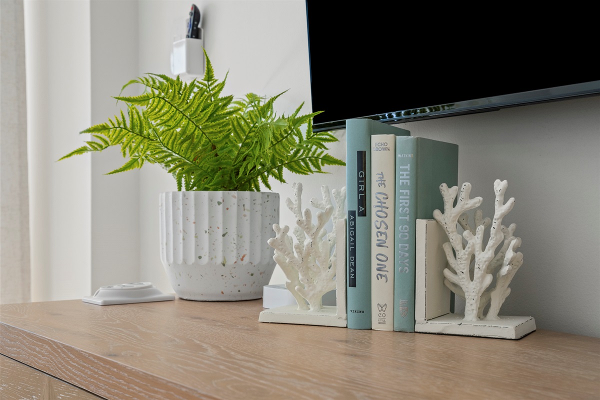 Styled with coastal charm, this space features sea-inspired books, white coral accents, and fresh greenery for a breezy, curated touch.