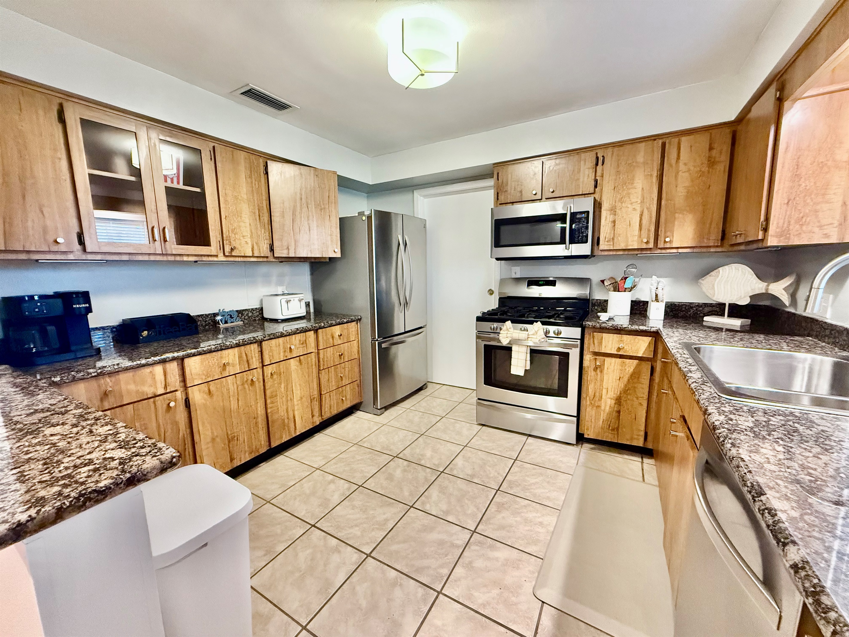 Warm wood cabinetry meets modern convenience in this stylish and functional kitchen.