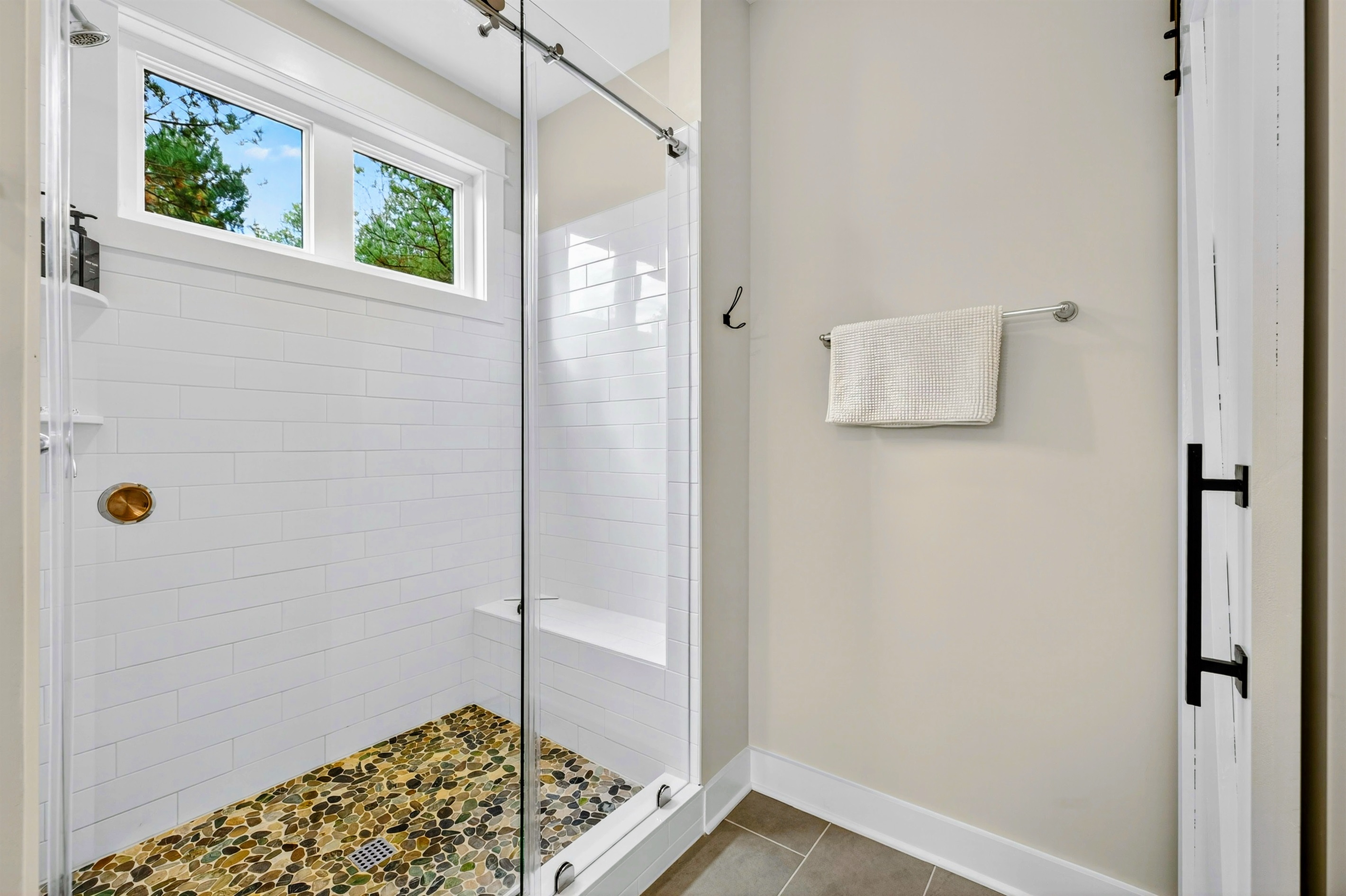 Guests will love the large shower with sliding glass barn style doors, pebble floors and the natural light that comes in from the windows!