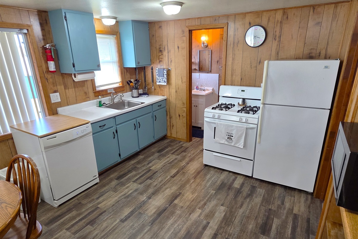 The kitchen has been updated with new flooring, fresh painted cabinets, all new plates, cutlery, pots & pans, a gas stove, full size refrigerator, more!