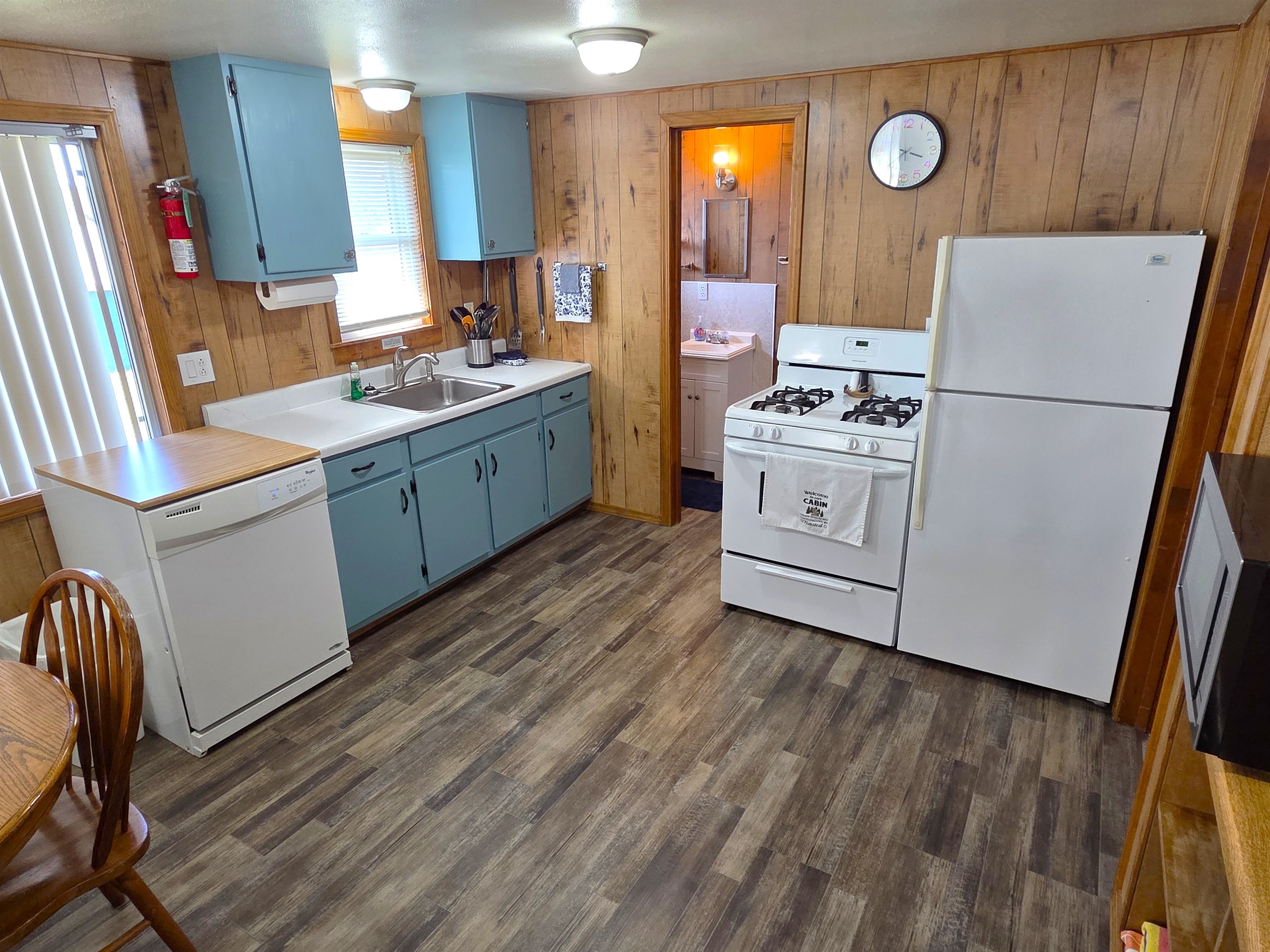 The kitchen has been updated with new flooring, fresh painted cabinets, all new plates, cutlery, pots & pans, a gas stove, full size refrigerator, more!