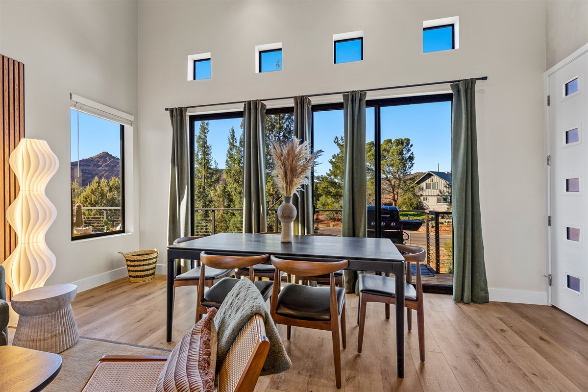 A bright dining area with large windows and deck access, offering a comfortable space to gather for meals while enjoying Sedona’s desert scenery.