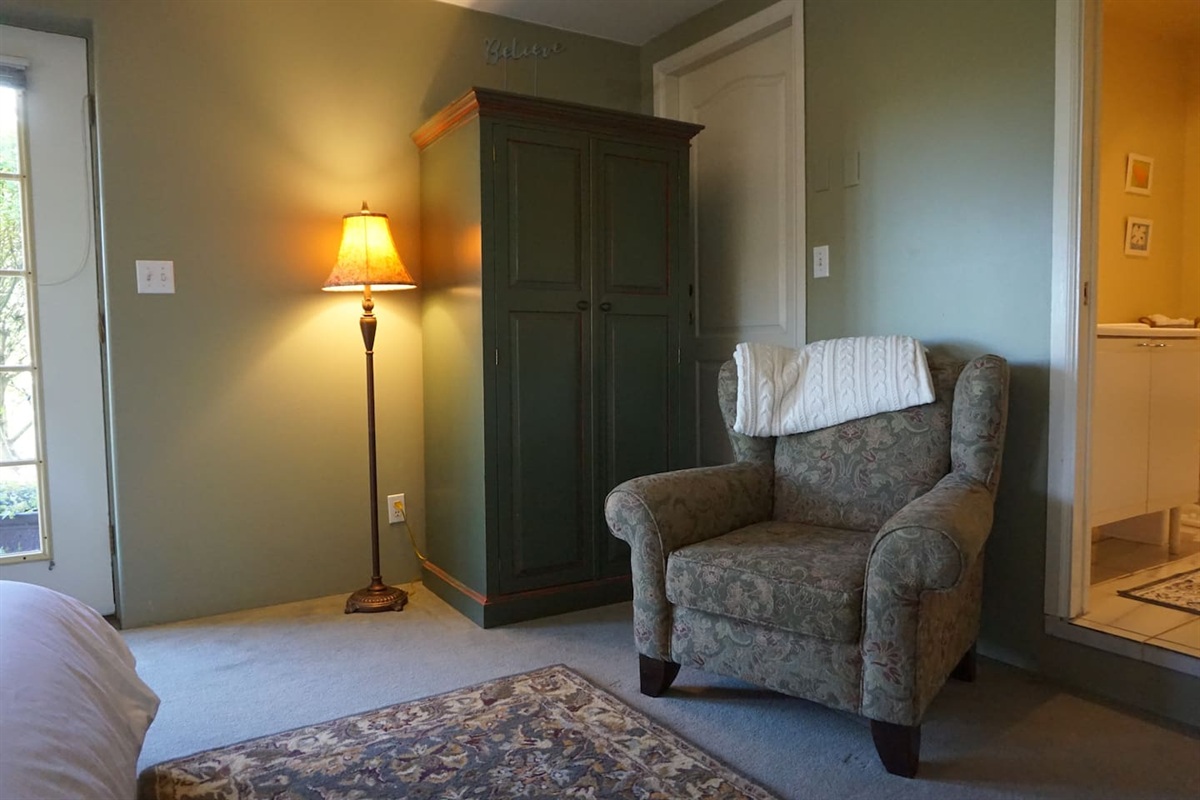 Comfy chair and wardrobe in the Garden Room.