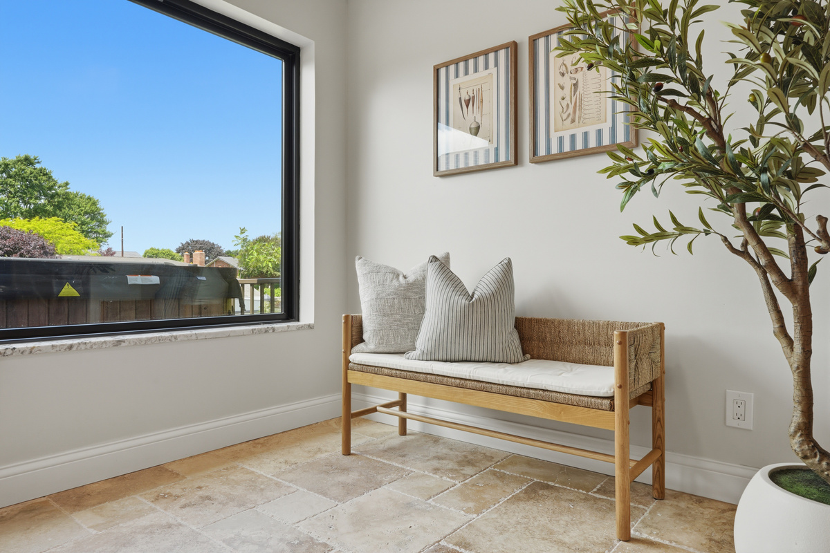 Bright and inviting sitting nook with a cozy bench, large window, and natural light. Clean, modern space perfect for reading, relaxing, or enjoying peaceful neighborhood views.