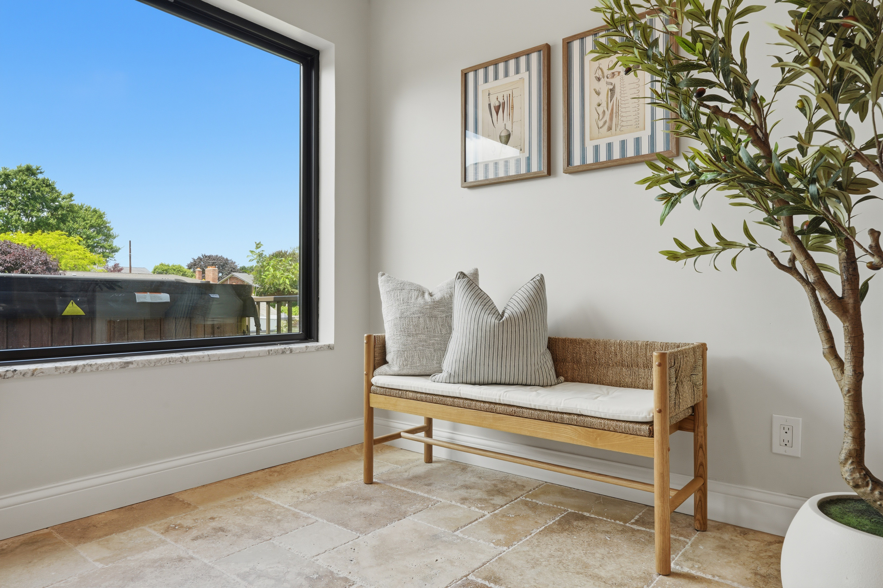 Bright and inviting sitting nook with a cozy bench, large window, and natural light. Clean, modern space perfect for reading, relaxing, or enjoying peaceful neighborhood views.