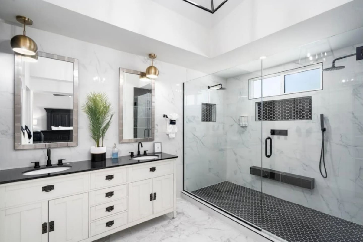 Spa-inspired primary bath with marble accents, frameless glass shower, and elegant finishes.