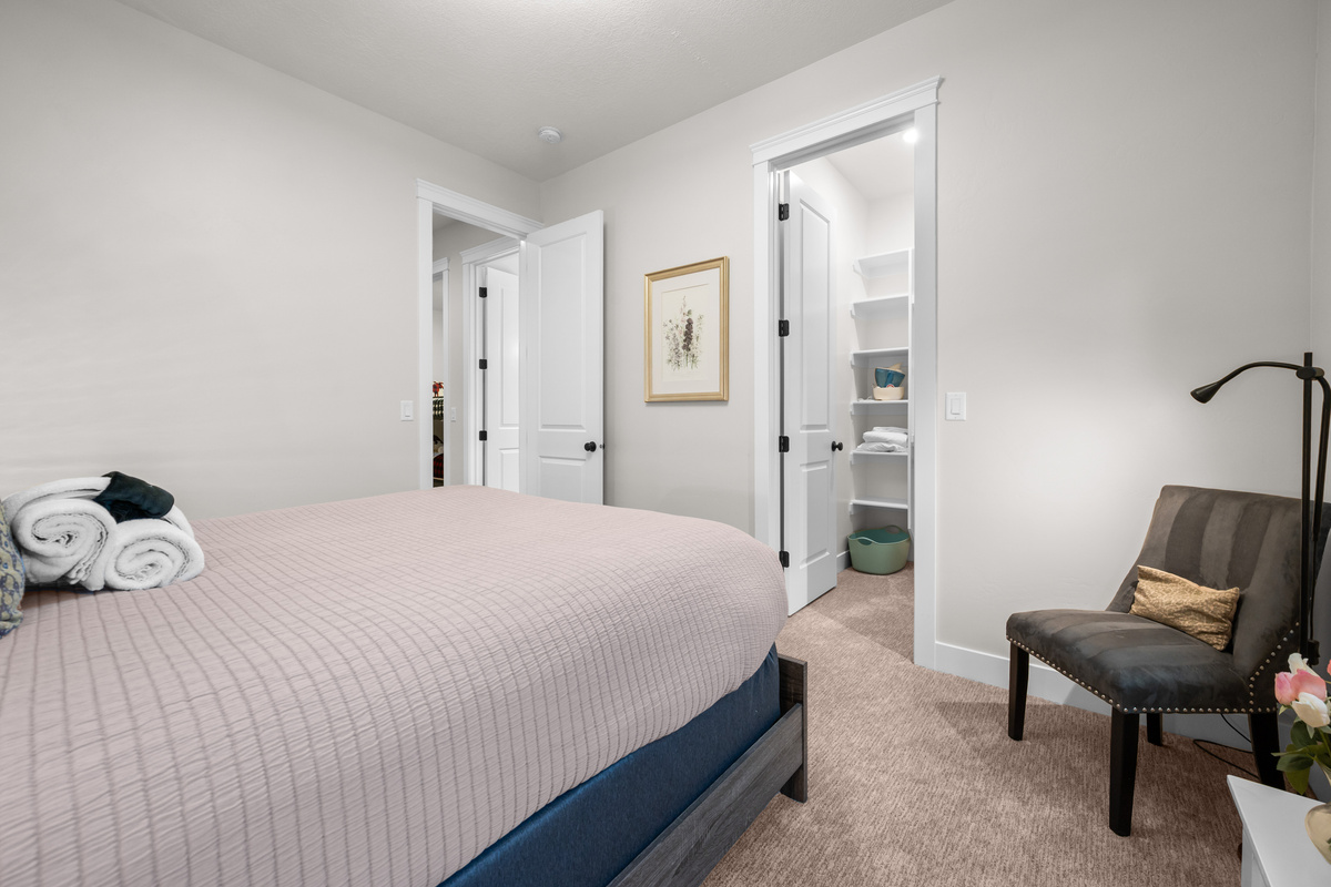 Spacious lower-level queen bedroom with comfortable seating and walk-in closet.