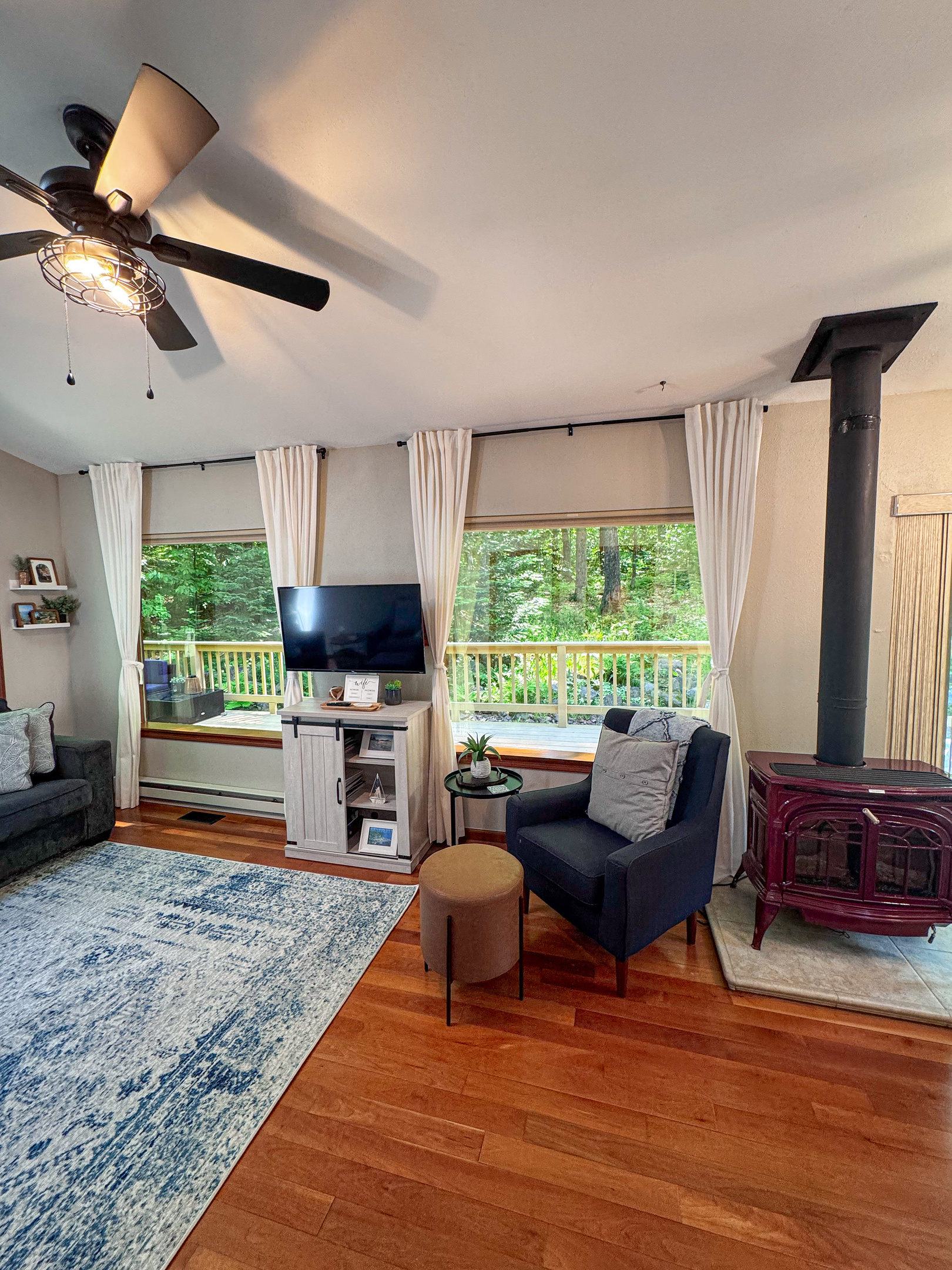 Main cottage living room view out windows- two huge panoramic mirror reflective windows overlooking the woods