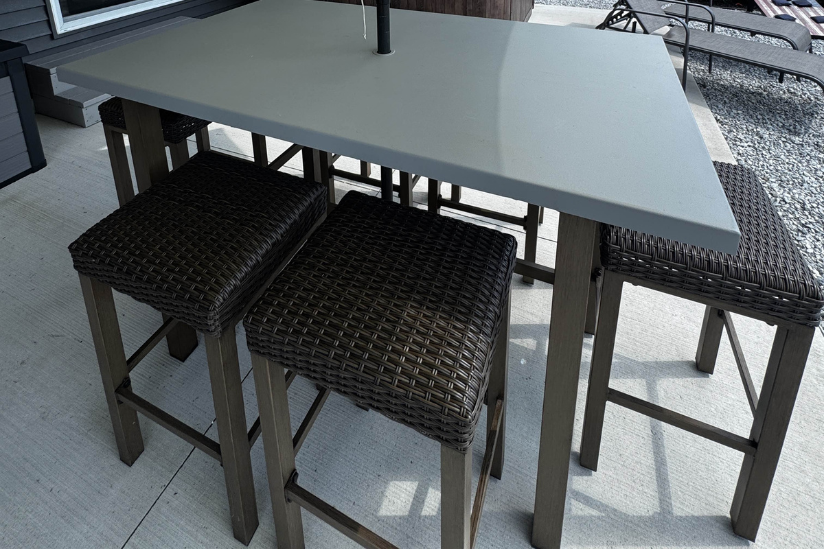 Outdoor dining table with woven seating—perfect for casual meals and relaxing on the waterfront patio.