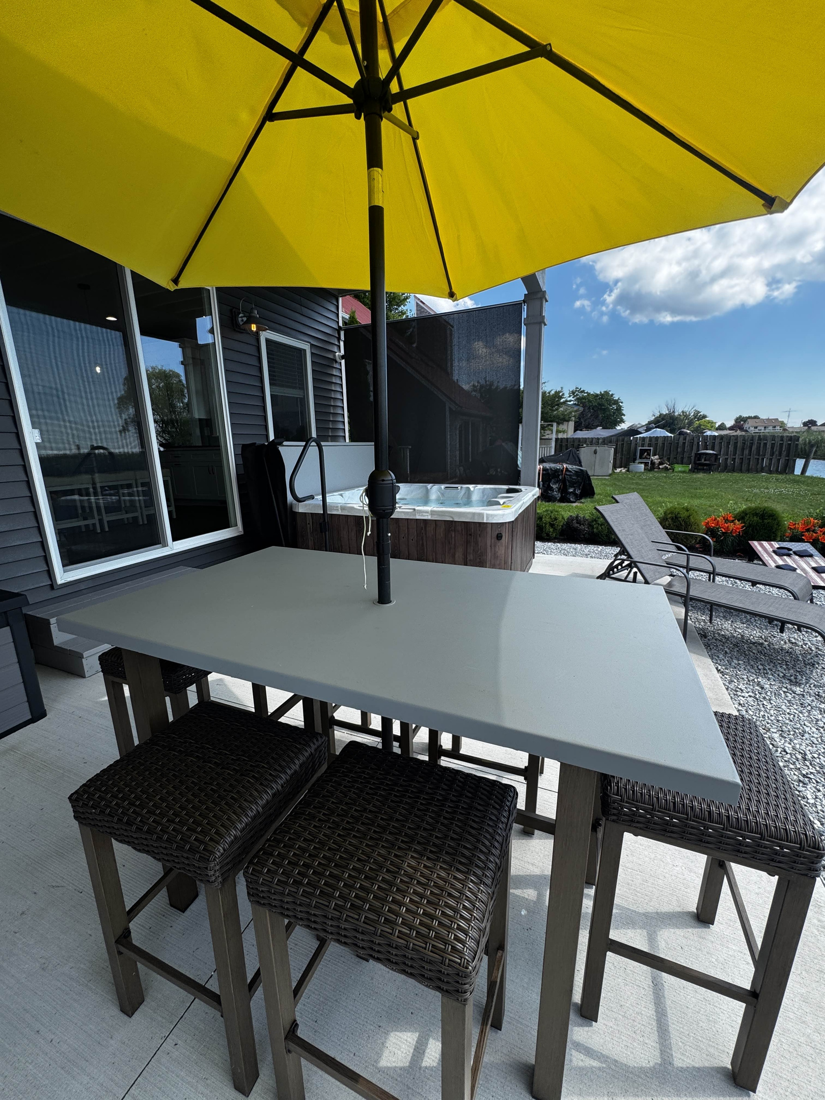 Outdoor dining table with woven seating—perfect for casual meals and relaxing on the waterfront patio.