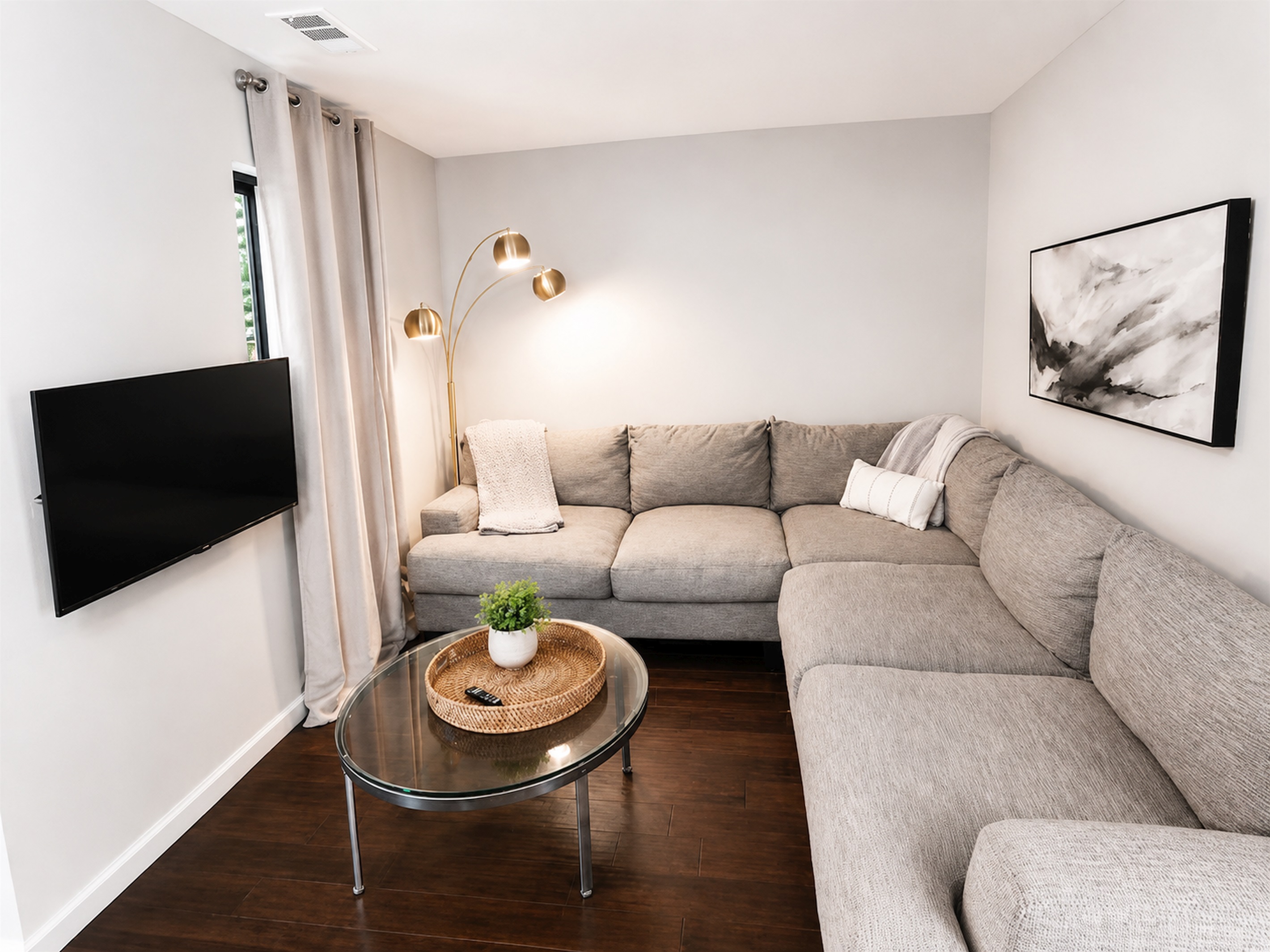 Cozy secondary lounge/media room with oversized sectional and smart TV — ideal for movie nights or kids’ hangouts