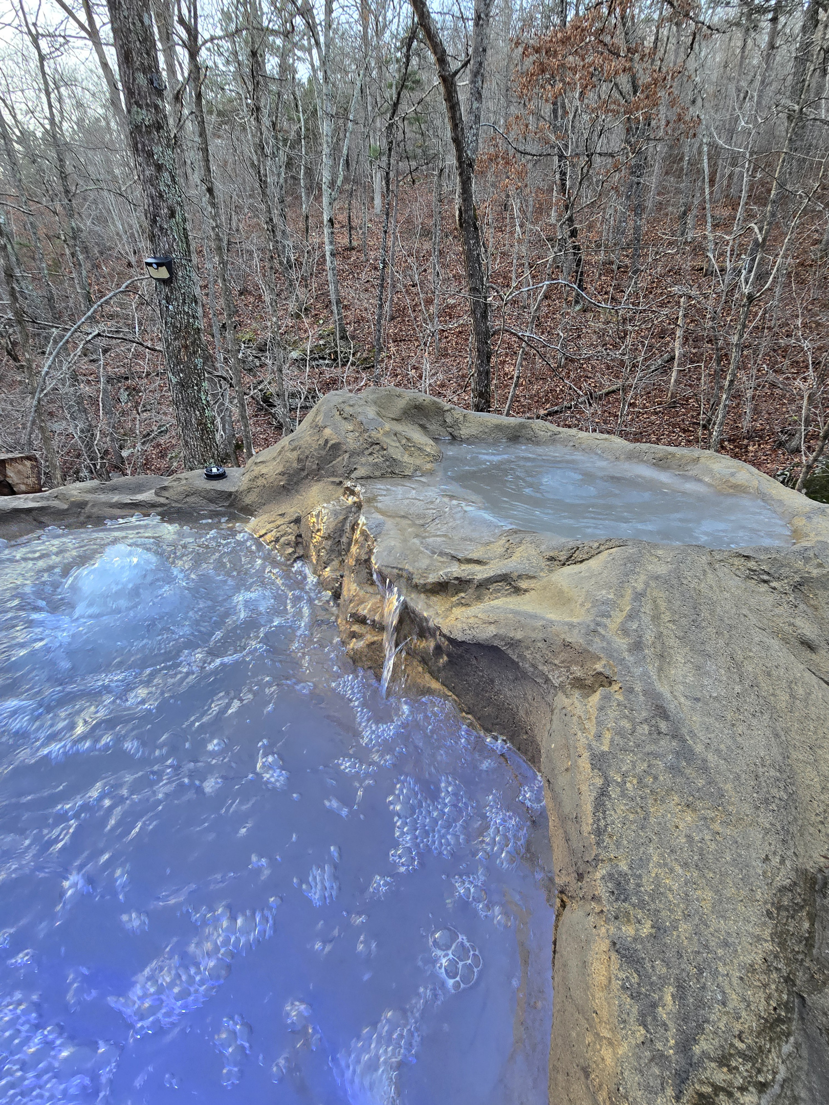 Boulder Hot Tub With Waterfall next to the creek and falls