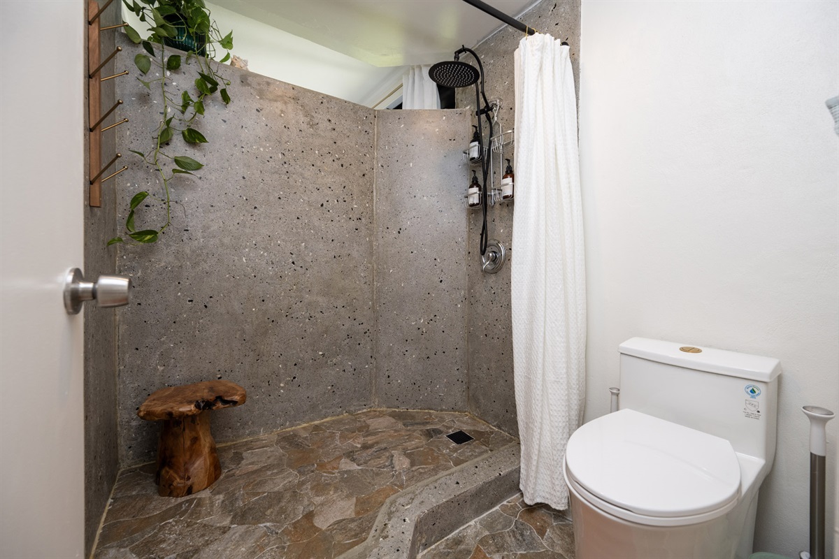 Soak in the calm of the rainfall shower, surrounded by natural stone.