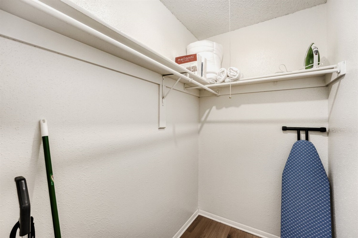 Spacious walk-in closet with shelving and storage for cleaning essentials.