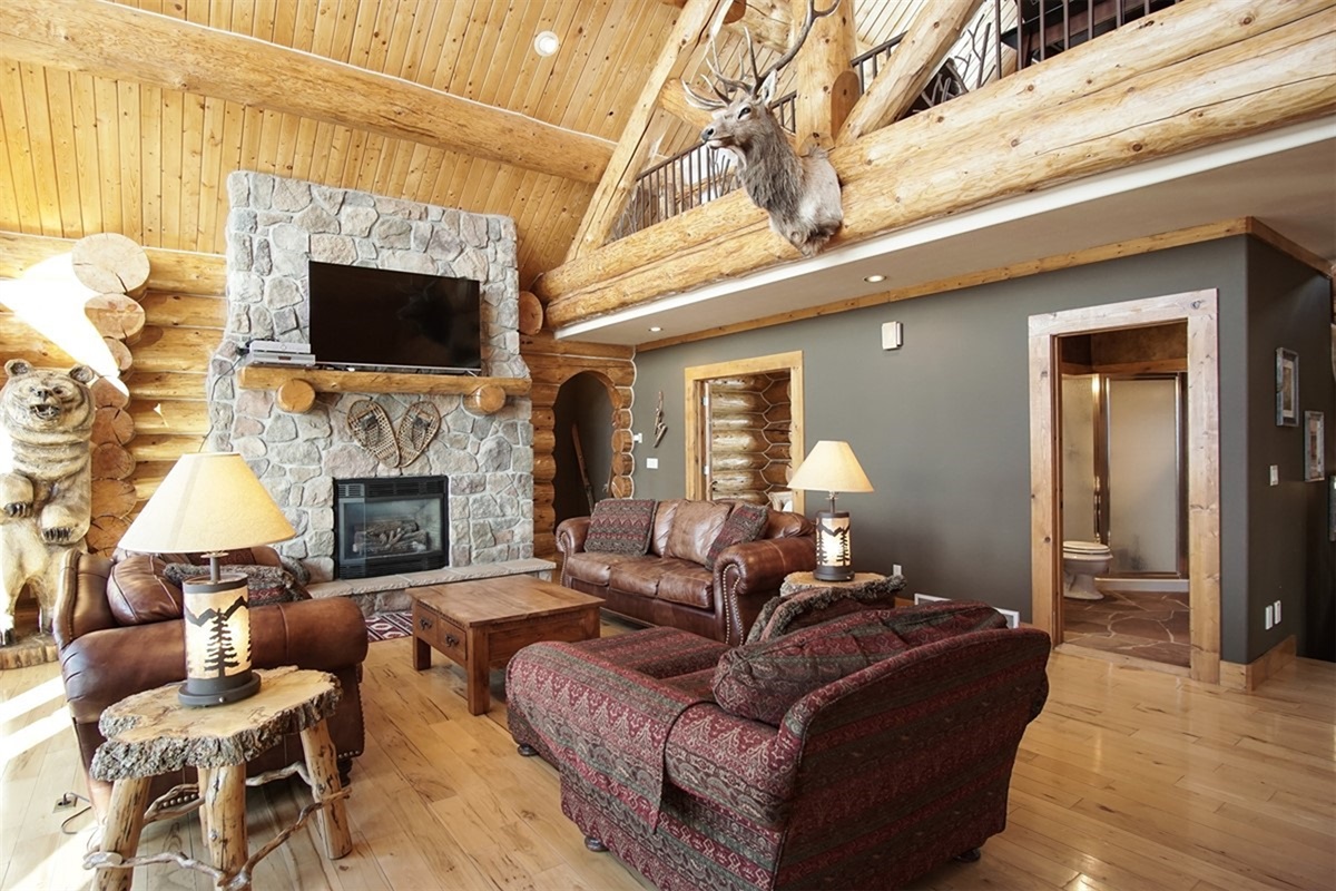 Rustic log cabin living room with fireplace—perfect for relaxing after skiing