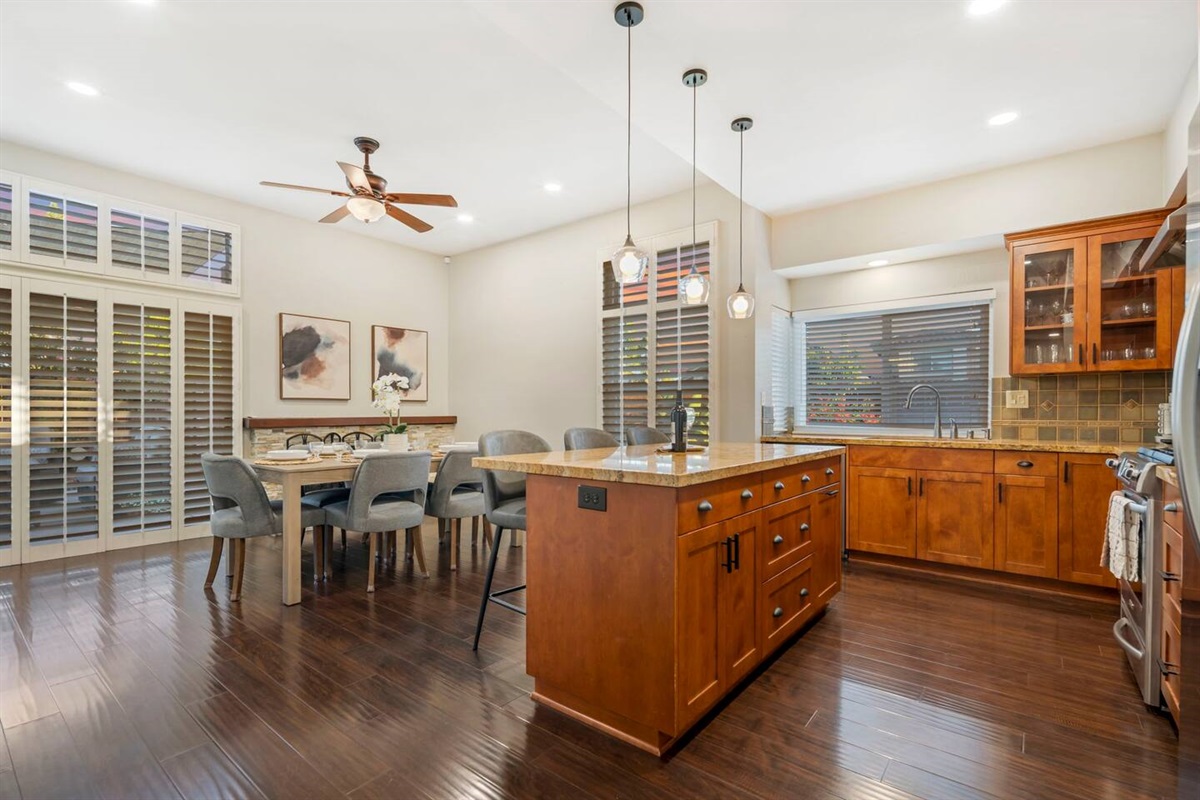 The dining room comfortably seats six and features a sliding door that opens to the backyard for easy outdoor access. A kitchen island with three barstools provides extra seating, making it ideal for both formal meals and casual gatherings.
