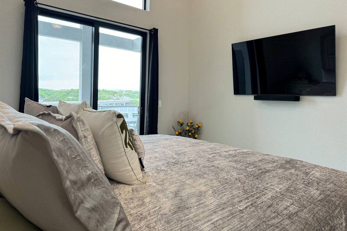 Master bedroom has King bed, night stands, TV with sound system, and slider door access to the balcony. 
