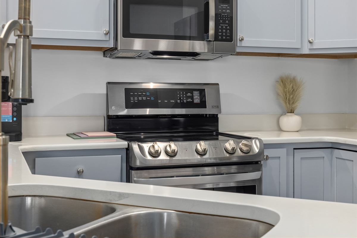 This open-concept kitchen features generous prep space, modern full-size appliances, and casual bar seating — perfect for morning coffee, easy lunches, and evenings spent cooking and connecting. Designed to feel as inviting as it is practical.