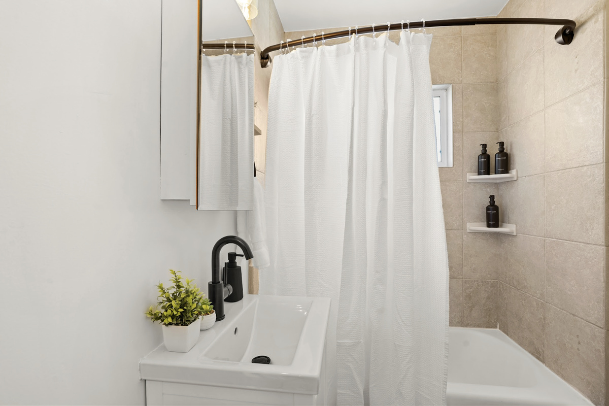 Clean contemporary bathroom with a full tub and shower