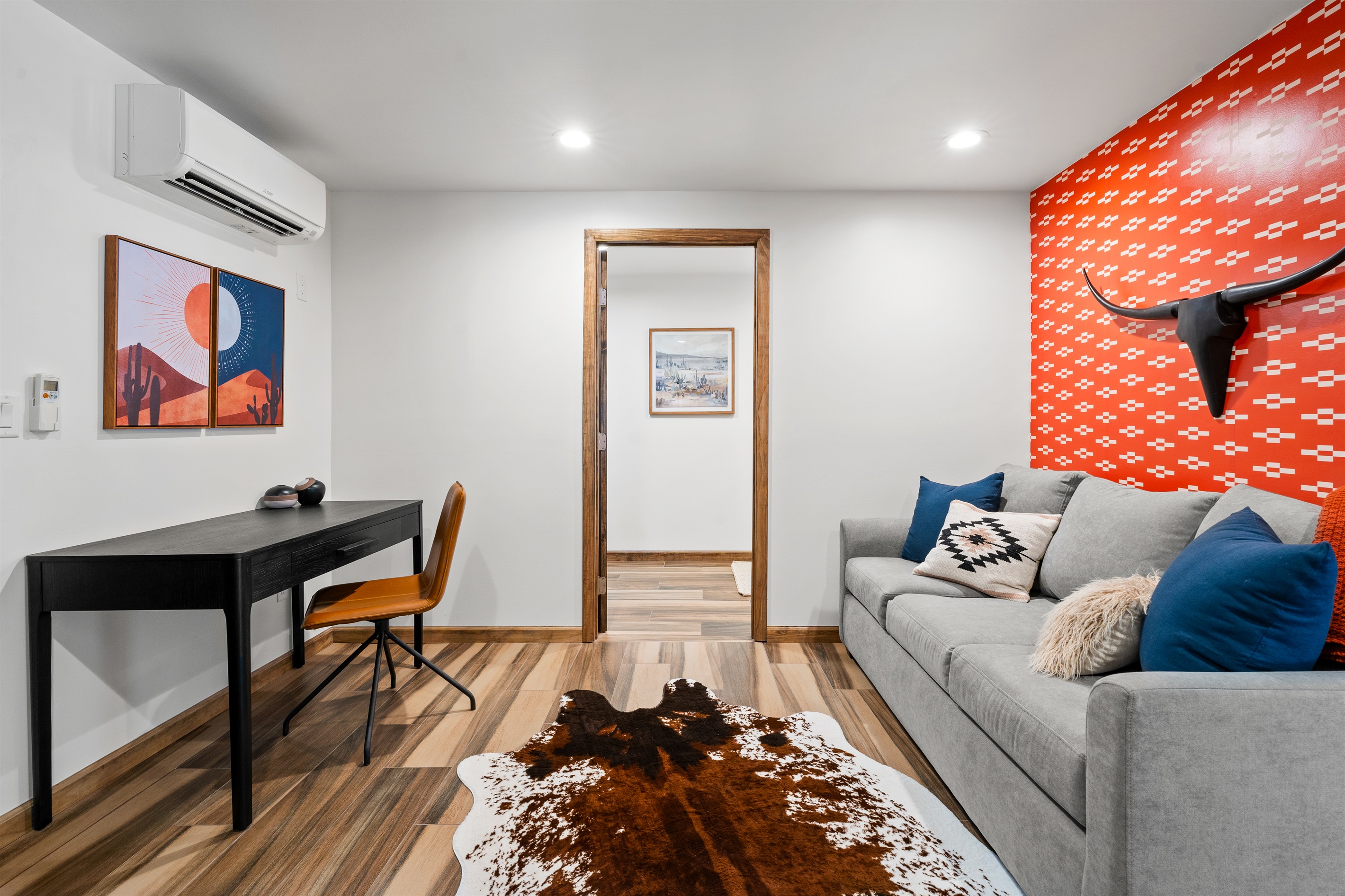 Bright workspace with Southwestern art and a cozy queen sofa bed.
