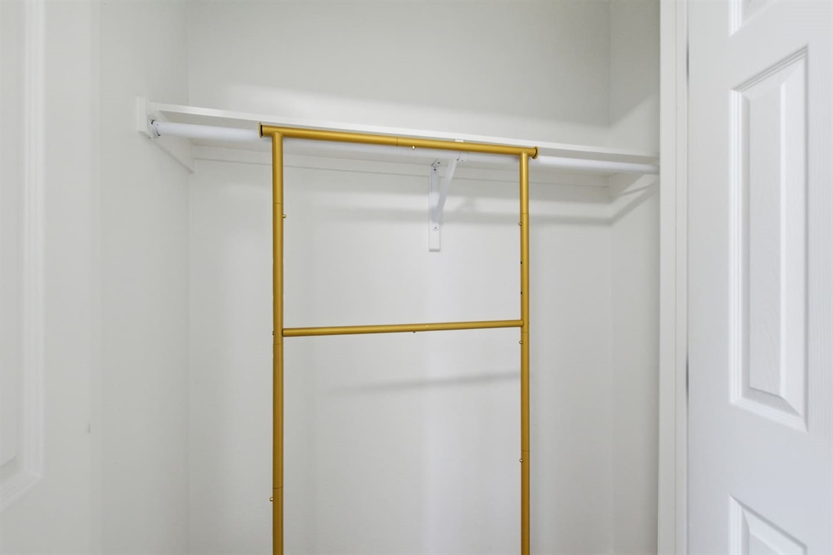 Laundry area with washer, dryer, shelving, and hanging space for extended stays.