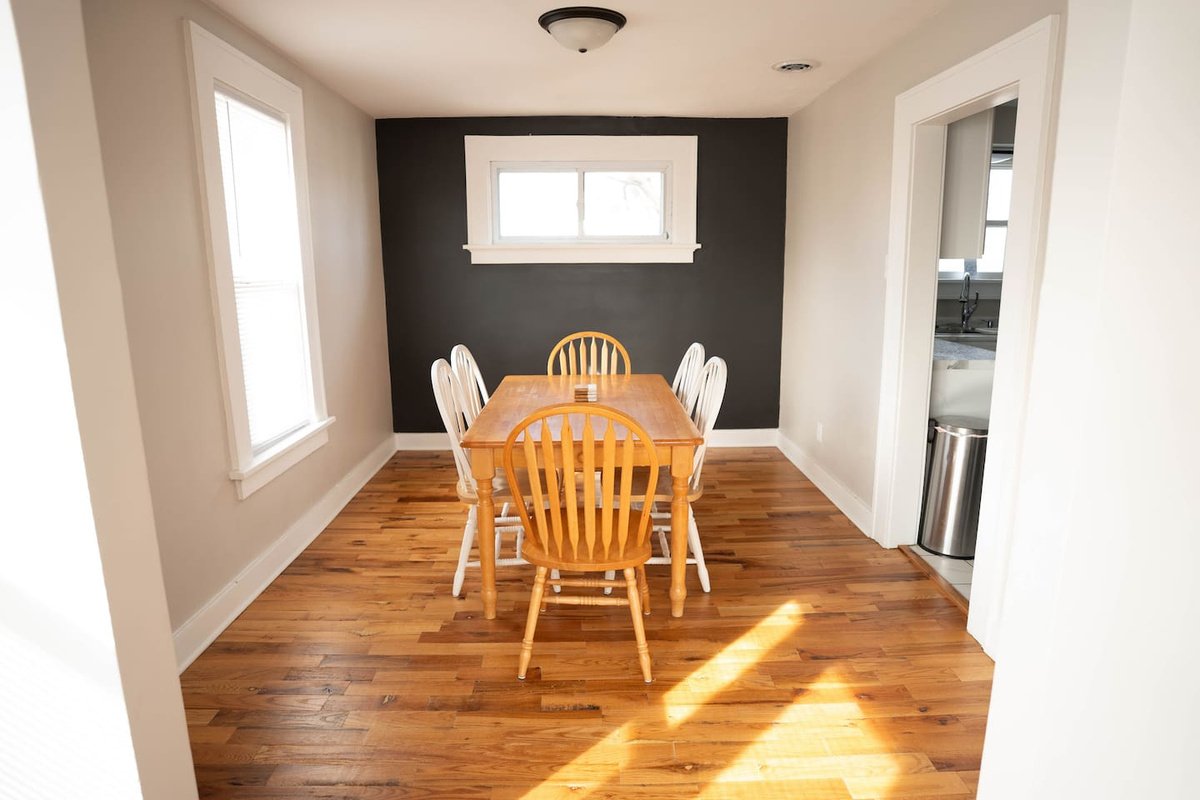 The dining area has a solid wooden table with six chairs, great for meals or hanging out. 