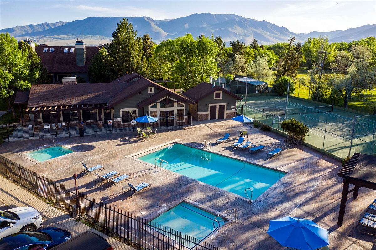 Resort-style amenities await with a sparkling community pool and surrounding lounge areas set against scenic mountain views.